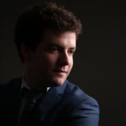 Headshot of Alasdair Macrae wearing a blue suit